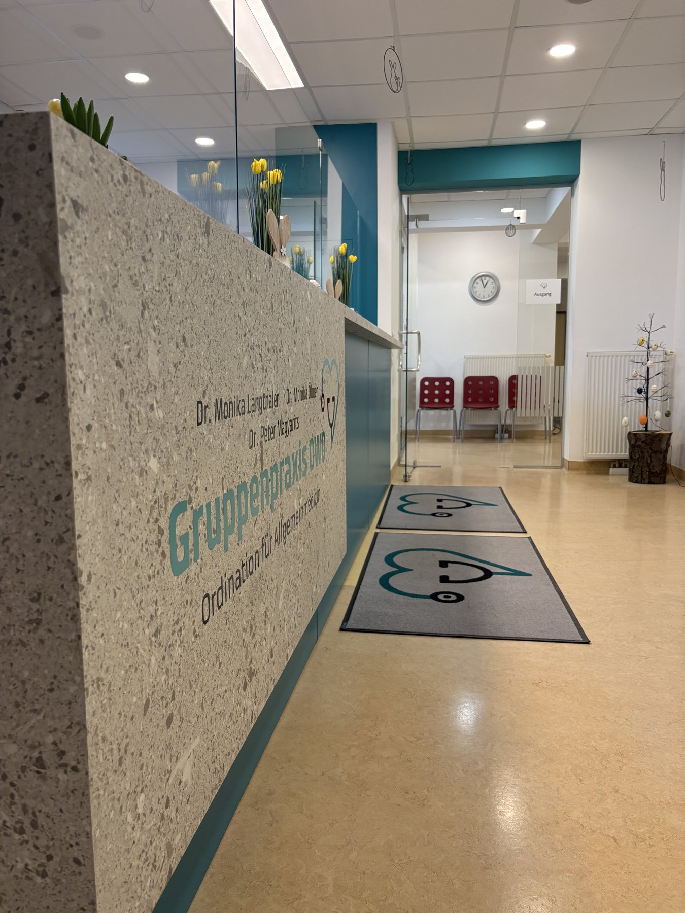 Blick vom Empfang in den Gang mit nummerierten Behandlungsräumen