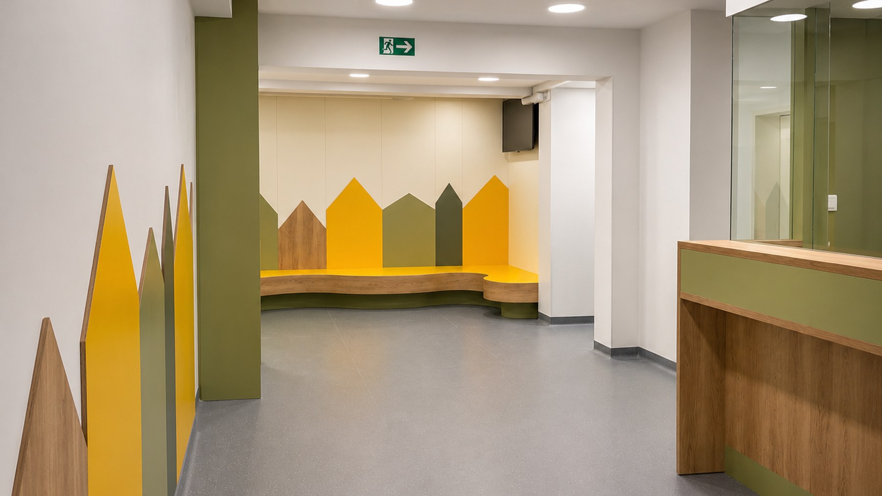 Empfangsbereich der Kinderordination mit Anmeldetresen aus Holz und einer Wandgestaltung aus gelben und grünen Häuschen